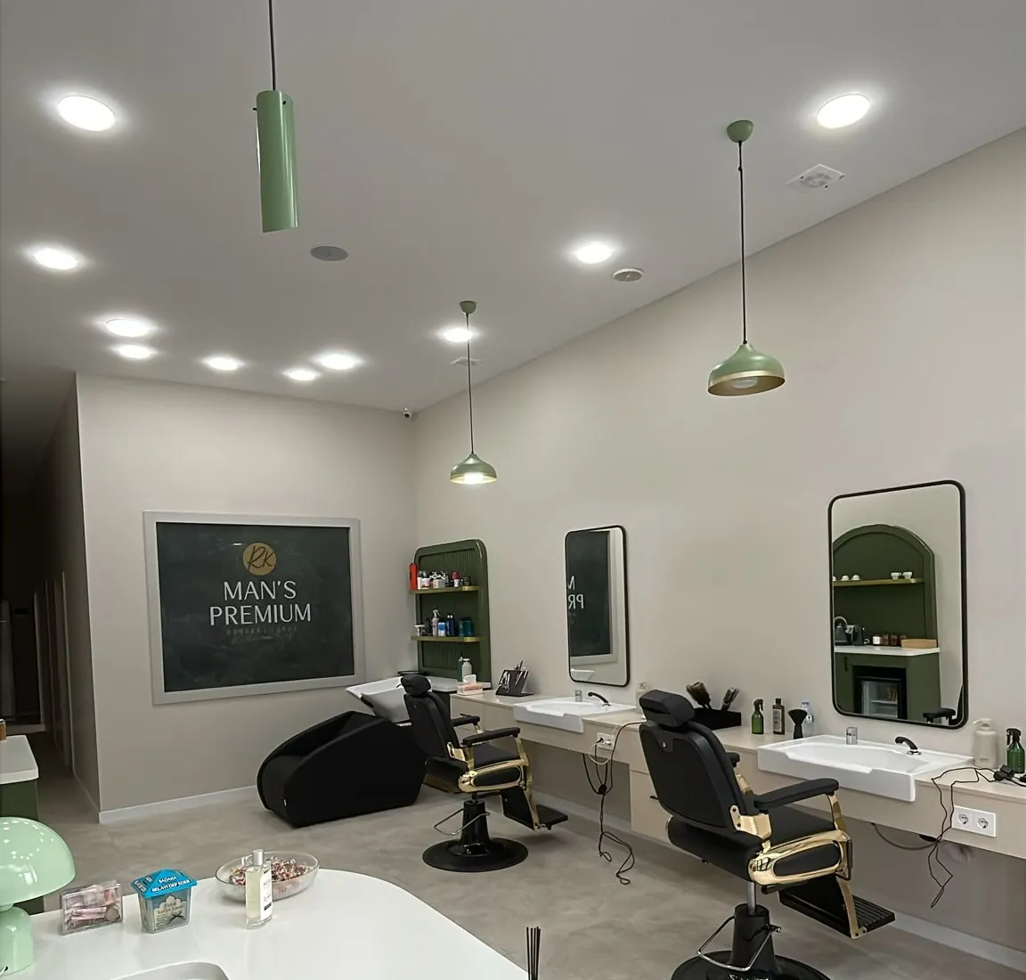 Ana salon: koltuklar, aynalar ve nane yeşili sarkıt lambalar