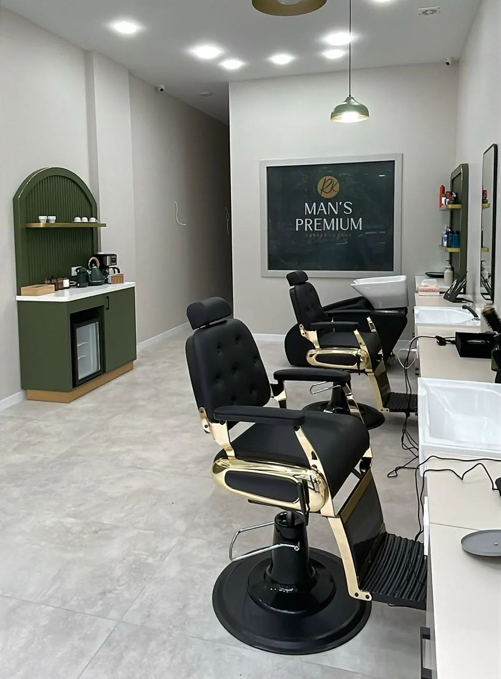 Man's Premium ana salonu: altın detaylı siyah deri berber koltukları ve zeytin yeşili kahve köşesi